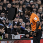 Referee reviewing VAR decision during football match 